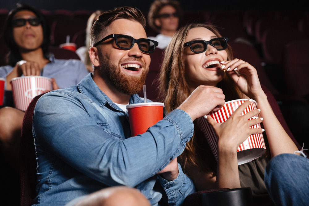 Picture,Of,Happy,Friends,Sitting,In,Cinema,Watch,Film,Eating